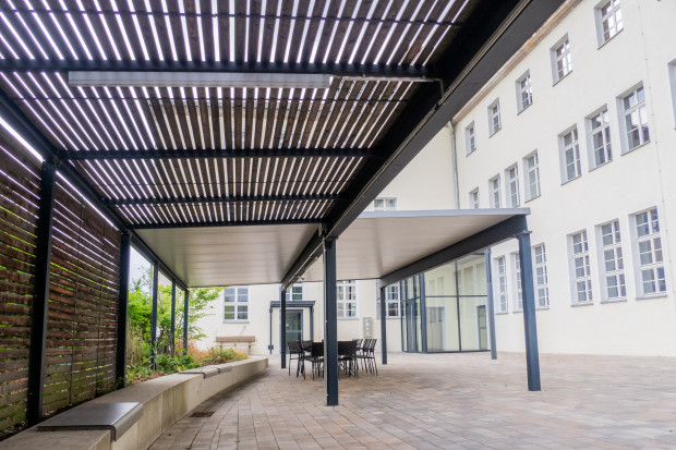 Aufenthaltsbereich mit Trapezblechdach und offener Lattung als Pergola
